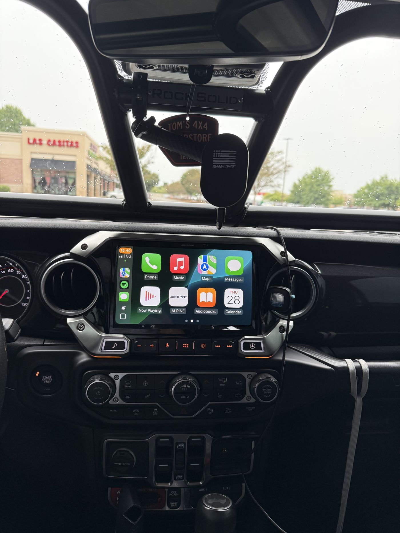 Alpine Restyle i509 head unit with wireless CarPlay running, Rock Solid Fab cage and BulletPoint mirror mount visible